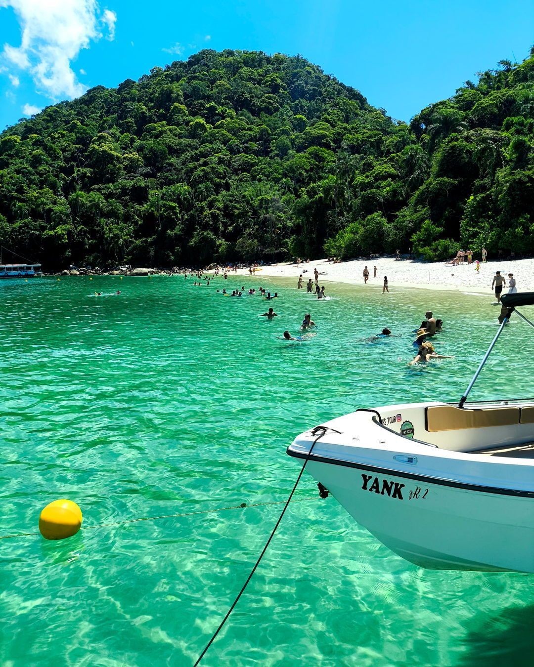 Aguas verdes cristalinas con turistas nadando en Arraial do Cabo